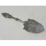 An ornate silver cake slice,