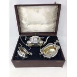 An ornate George V three piece boxed silver gilt tea set,