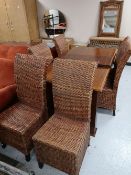 A reproduction extending dining table and six wicker chairs