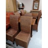 A reproduction extending dining table and six wicker chairs