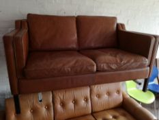 A Scandinavian two seater brown leather settee.