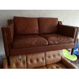 A Scandinavian two seater brown leather settee.