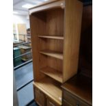 A teak effect bookcase fitted with cupboards