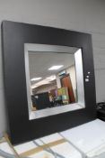 A contemporary black framed mirror