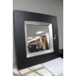 A contemporary black framed mirror