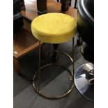 A pair of contemporary bar stools with mustard colour seats