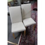 A pair of cream vinyl dining chairs
