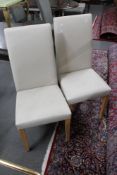 A pair of cream vinyl dining chairs