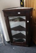 A nineteenth century oak glazed corner cabinet