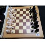 A beech chess board with carved resin pieces