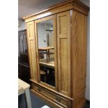 An Edwardian mirrored door wardrobe fitted with a drawer