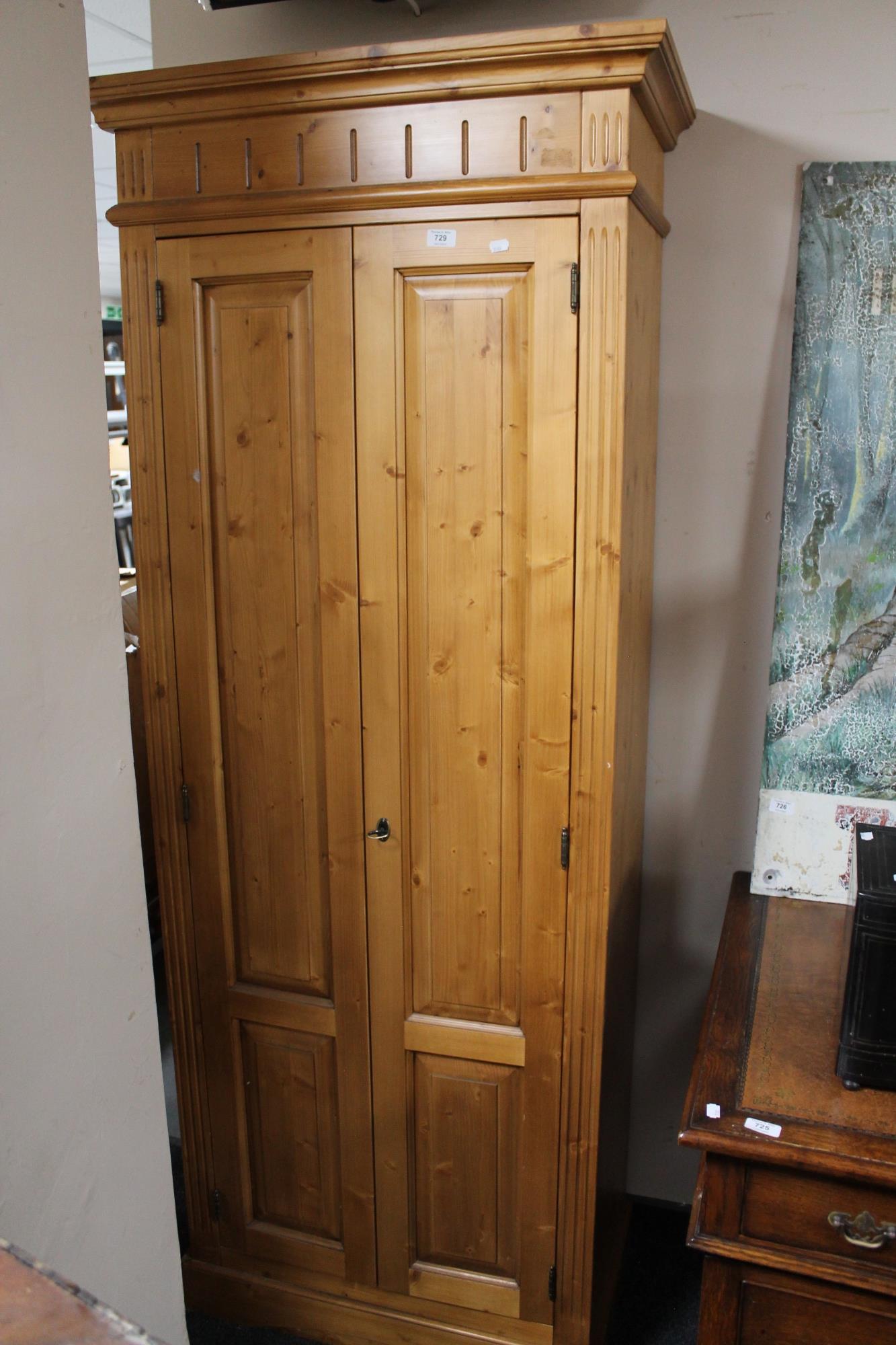 A pine double door cabinet fitted with shelves