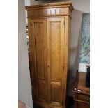 A pine double door cabinet fitted with shelves