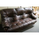 A three piece brown leather lounge suite with wooden frame
