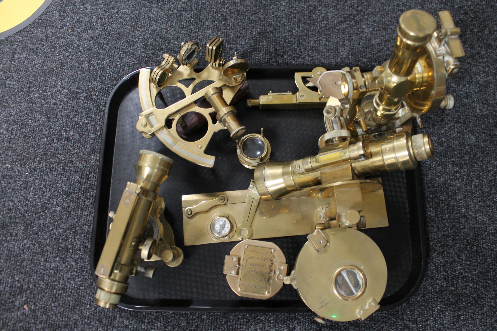 A collection of brass surveying instruments, compass, sextant,