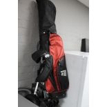 A golf bag with trolley and clubs