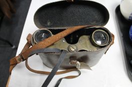 A pair of antique brass binoculars in leather case