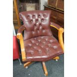 A Burgundy buttoned leather swivel chair