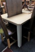 A contemporary oak topped pull out table on painted legs