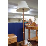 A teak standard lamp and shade