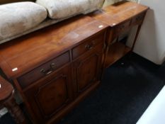 An inlaid yew wood double door cabinet fitted with two drawers together with a two tier hall table