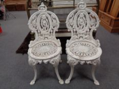 A pair of painted cast iron patio chairs