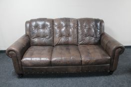 A brown leather three seater settee and two seater settee with matching storage footstool