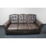 A brown leather three seater settee and two seater settee with matching storage footstool