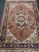 A Persian woolen carpet on orange ground