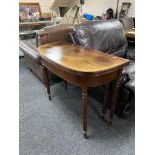 A reproduction mahogany D-shaped turn over topped tea table on tapered legs