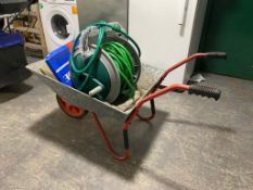 A galvanised wheel barrow together with a hosepipe on reel