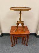 A nest of three stained pine tables together with an inlaid pie crust wine table on four way