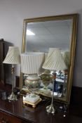A gilt framed bevelled mirror together with a pair of contemporary table lamps,