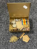 A tin containing WWI and WWII British military medals and badges