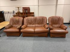 A brown leather three piece lounge suite