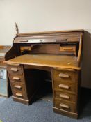 An Edwardian oak roll topped desk