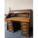 An Edwardian oak roll topped desk