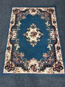 A contemporary striped rug together with a floral rug on blue ground