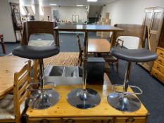 A contemporary poser bar table on chrome pedestal base and pair of matching bar chairs