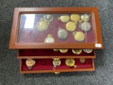 A pocket watch display case containing thirty assorted contemporary pocket and fob watches