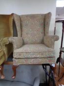 A reproduction Queen Anne style armchair in floral covering