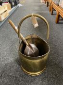 An antique brass coal bucket with shovel