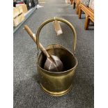 An antique brass coal bucket with shovel