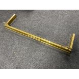 An antique brass fire curb