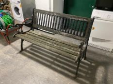 A wrought iron wooden slatted garden bench