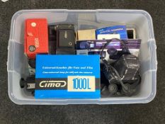 A clear plastic storage crate with lid containing cameras, Olympus OM1, digital camera, cine camera,