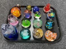A tray of sixteen assorted glass paperweights