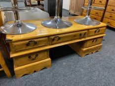 A varnished pine twin pedestal low table fitted with five drawers