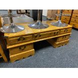 A varnished pine twin pedestal low table fitted with five drawers