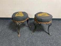 A pair of vintage cast iron bar stools on painted legs upholstered in Guinness fabric